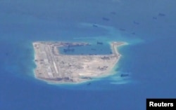 FILE - Chinese dredging vessels are purportedly seen in the waters around Fiery Cross Reef in the disputed Spratly Islands in the South China Sea in this still image from video taken by a P-8A Poseidon surveillance aircraft provided by the United States Navy.