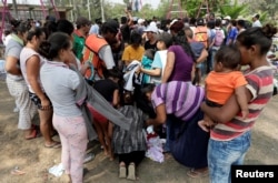 Central American migrants receive donated clothes as they take a break from traveling in their caravan, on their journey to the U.S., in Matias Romero, Oaxaca, Mexico, April 3, 2018.