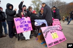 FILE - Rep. Luis Gutierrez, D-Ill., right, speaks with Lenka Mendoza of Dumfries, Va., who is originally from Peru, during a rally in front of the White House in support of executive action addressing immigration reform, Nov. 19, 2014. Mendoza has two children who qualified for DACA.
