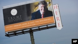 FILE - A Trump Ocean Resort Baja billboard with a photo of Donald Trump advertises condos for sale on the outskirts of Tijuana, Mexico. But the Trump Ocean Resort Baja Mexico project collapsed, and dozens of buyers who lost their 30 percent deposits sued.