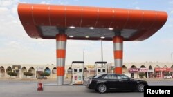 FILE - A driver waits to fill his car with fuel at a gas station in Riyadh, Saudi Arabia, Dec. 22, 2015.