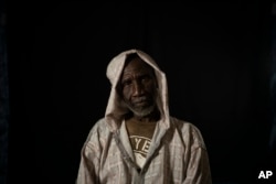 FILE - Cheikh Fofana poses for a picture before an interview in Goudiry, Senegal, Nov. 26, 2018. Fofana grieves his son, Tidiane's absence, even while refusing to officially acknowledge he is dead.