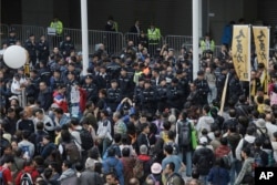 FILE - Police officers are surrounded by protesters at the Hong Kong Government Headquarters in Hong Kong, Jan. 1, 2018.