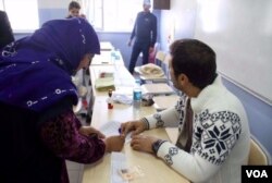 A voter checks in at the polling station in Diyarbakir Sunday morning. VOA journalists in the city report the voting was generally calm, although a few problems occurred. (Mutlu Civiroglu/VOA),