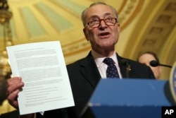 Senate Minority Leader Charles Schumer of N.Y., holds up a letter to Republicans about healthcare while speaking to the media, May 9, 2017, on Capitol Hill in Washington.