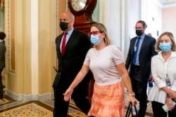 Sen. Kyrsten Sinema, D-Ariz., walk to the Senate Chamber in Washington, Oct. 5, 2021.