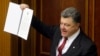 Ukraine's President Petro Poroshenko shows a signed landmark association agreement with the European Union during a session of the parliament in Kyiv, Sept. 16, 2014. 