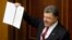 Ukraine's President Petro Poroshenko shows a signed landmark association agreement with the European Union during a session of the parliament in Kyiv, Sept. 16, 2014. 