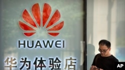 A man uses his smartphone outside of a shop selling Huawei products at a shopping mall in Beijing, Wednesday, May 29, 2019. Chinese tech giant Huawei filed a motion in U.S. court Wednesday challenging the constitutionality of a law that limits its…