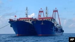 FILE - In this photo provided by the National Task Force-West Philippine Sea, Chinese vessels are moored at Whitsun Reef, South China Sea on March 27, 2021.