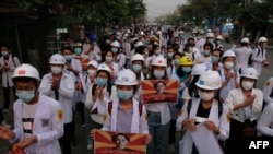 Protesters take cover during clashes with security forces in Monywa, Myanmar, March 21, 2021, in this still image from a video obtained by Reuters.