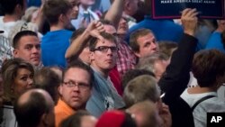 Supporters of Republican presidential candidate Donald Trump react toward reporters and photographers during a campaign rally in Cincinnati, Oct. 13, 2016.