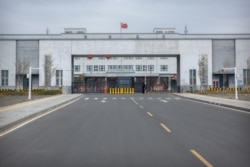 FILE - Police officers stand at the outer entrance of the Urumqi No. 3 Detention Center in Dabancheng in western China's Xinjiang Uyghur Autonomous Region, April 23, 2021.
