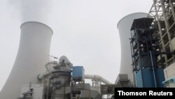 FILE PHOTO: Water vapour rises from a cooling tower of a China Energy ultra-low emission coal-fired power plant during a media tour, in Sanhe