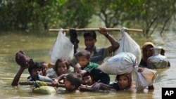 A Rohingya family reaches the Bangladesh border after crossing a creek of the Naf river on the border with Myanmmar, in Cox's Bazar's Teknaf area, Sept. 5, 2017.