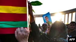 A woman reacts in front of the casket of a member of the Kurdish Asayish security forces, killed a day earlier in a Turkish drone strike, during his funeral in Amuda, Syrian, on Oct. 7, 2023.