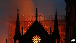 FILE - Flames and smoke rise from Notre Dame cathedral as it burns in Paris, Monday, April 15, 2019. (AP Photo/Thibault Camus)