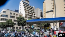 FILE - Scooter motorists queue for fuel outside a gas station in Lebanon's capital Beirut on June 29, 2021. 