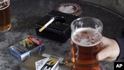 Cigarette packets sporting graphic health pictures lie on a table while workers have a drink a a local pub in Sydney, Australia, July 6, 2011.