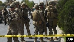  FILE - U.S. soldiers and Afghan security personnel investigate at the site of an attack in Kabul, Afghanistan, Sept. 24, 2017.