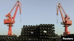 FILE - Cranes are seen above piles of steel pipes to be exported at a port in Lianyungang, Jiangsu province, China, Dec. 1, 2015. 