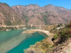 Rescuers leave on a boat to search for bodies in the downstream of Alaknanda River in Rudraprayag, northern state of Uttarakhand, India, Feb.8, 2021.