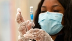 FILE - A health worker loads syringes with the vaccine on the first day of the Johnson & Johnson vaccine being made available to residents at the Baldwin Hills Crenshaw Plaza in Los Angeles. California, March 11, 2021.