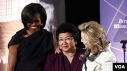 Presiden Kirgistan Roza Otunbayeva menerima penghargaan, diapit Ibu Negara Michelle Obama (kiri) dan Menlu AS Hillary Clinton.