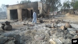 A man walks past burnt out houses following an attack by Boko Haram in Dalori village 5 kilometers (3 miles) from Maiduguri, Nigeria, Jan. 31, 2016.