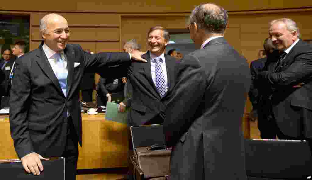 French Foreign Minister Laurent Fabius, left, speaks with Slovenian Foreign Minister Karl Erjavec, center, during a round table meeting of EU foreign ministers in Luxembourg, Oct. 20, 2014.