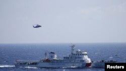 A Chinese ship and helicopter are seen during a search and rescue exercise near Qilian Yu subgroup in the Paracel Islands, which is known in China as Xisha Islands, South China Sea, July 14, 2016.