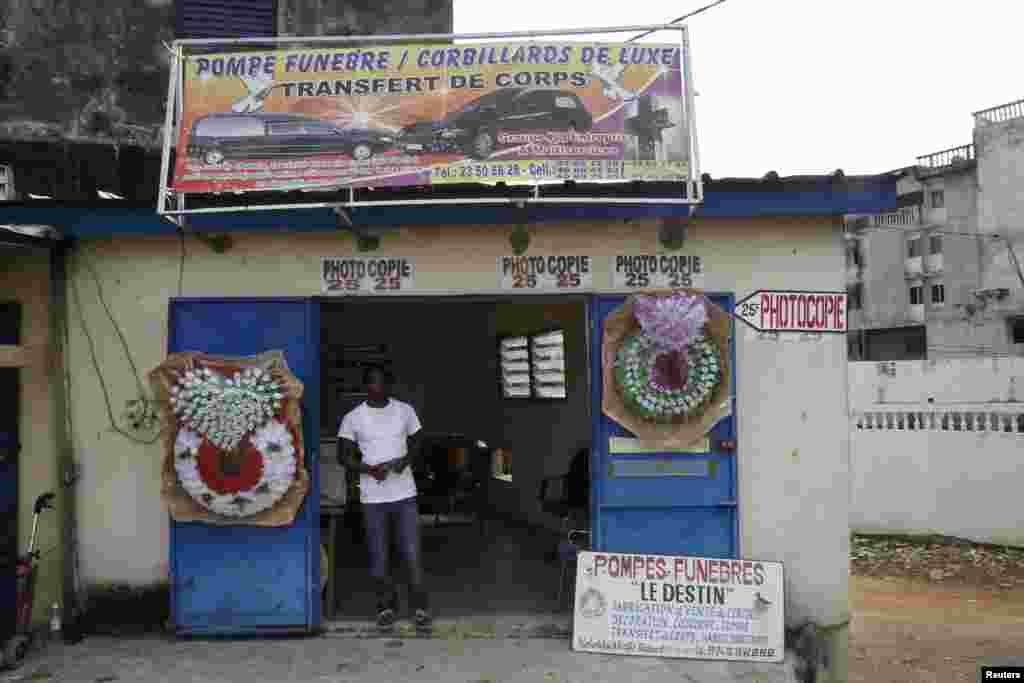 The owner of a funeral services shop stands in front of his shop near the mortuary of Yopougon in Abidjan, May 22, 2013.