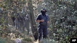 State police stand guard at the site where at least five bodies were found in a clandestine grave on the outskirts of Mexico City, February 27, 2011