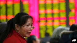 FILE - An investor speaks at a private securities company in Shanghai, China. 