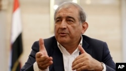 Sydney Muslim community leader Jamal Rifi, center, and his family members pray at a makeshift memorial after a siege at Martin Place in the central business district of Sydney, Australia Tuesday, Dec. 16, 2014.