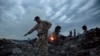 FILE - People walk amongst the debris at the crash site of a Malaysia Airlines flight MH17 near the village of Grabove, Ukraine, July 17, 2014.