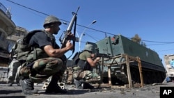 FILE - Lebanese army soldiers open fire during clashes with Islamic militants in the northern port city of Tripoli, Oct. 26, 2014.