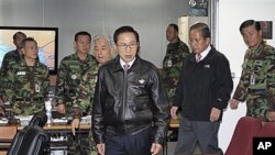 South Korean President Lee Myung-bak, center, arrives with Defense Minister Kim Tae-young, second right, in Seoul, South Korea, as the military was put on top alert after North Korea's artillery attack on the South Korean island of Yeonpyeong, 23 Nov 2010