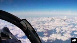 In this photo taken from a video distributed by Russian Defense Ministry Press Service, on Tuesday, Dec. 22, 2020, a Russian Tu-95 strategic bomber flies during a joint patrol mission over the Western Pacific. 
