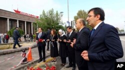 FILE - Turkish Prime Minister Ahmet Davutoglu, third right, his wife Sare Davutoglu, third left, his deputies Yalcin Akdogan, second right, and Cevdet Yilmaz, right, pray at the site of an explosion in Ankara, Turkey, Oct. 13, 2015.