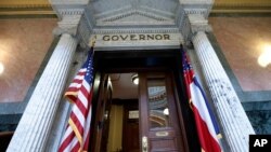 The Mississippi state flag is anchored across from the U.S. flag, outside the governor's office at the Capitol in Jackson, Mississippi, June 29, 2020, the day after the state Legislature passed a bill to replace the Confederate-themed flag. 
