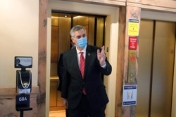 FILE - Georgia Secretary of State Brad Raffensperger waves to photographers as he walks to his office in the Capitol Building, in Atlanta, Jan. 4, 2021.