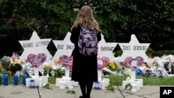 A person stands in front of Stars of David that are displayed in front of the Tree of Life Synagogue with the names of those killed in Saturday's shooting in Pittsburgh, Oct. 29, 2018.