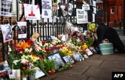 Bunga penghormatan, foto, dan plakat lainnya diletakkan oleh para pendukung Alexey Navalny di seberang Kedutaan Besar Rusia di London pada 1 Maret 2024. (Foto: AFP)