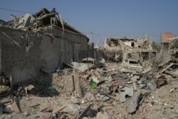 Ali Ibrahimov works on the ruins of his home, which was hit by a rocket, in the city of Ganja, Azerbaijan, Oct. 18, 2020.