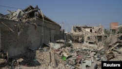 Ali Ibrahimov works on the ruins of his home, which was hit by a rocket, in the city of Ganja, Azerbaijan, Oct. 18, 2020. (Reuters)
