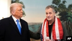 ২০২৫ সালের ১১ ফেব্রুয়ারি ওয়াশিংটনে হোয়াইট হাউসের কূটনৈতিক অভ্যর্থনা কক্ষে মার্ক ফোগেলকে সাথে নিয়ে বক্তব্য রাখছেন প্রেসিডেন্ট ডনাল্ড ট্রাম্প। ১১ ফেব্রুয়ারি, ২০২৫। .