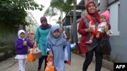 FILE - Indonesian girls with their mother leave a school-turned-clinic after the daughters were circumcised in Bandung, Feb. 10, 2013.