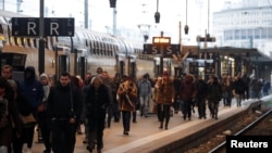 Passengers walk on a platform at the Gare de Lyon railway station in Paris as a strike by French SNCF railway workers and French transportation workers continue to protest against French government's pensions reform plans in France, Dec. 6, 2019.