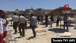 In this screen grab taken from video provided by Tunisia TV1, injured people are treated on a Tunisian beach at the resort town of Sousse, June 26, 2015. 